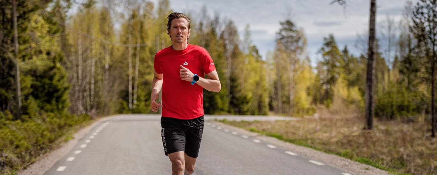 Johan Olsson springer på en asfalterad väg, kantad av skog