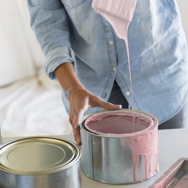 Kvinna som håller i målarpensel med rosa färg