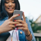 Bild på en tjej som håller i en mobiltelefon