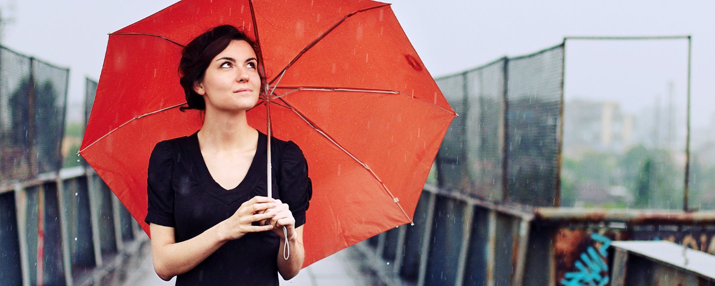 Ung kvinna med ett rött paraply