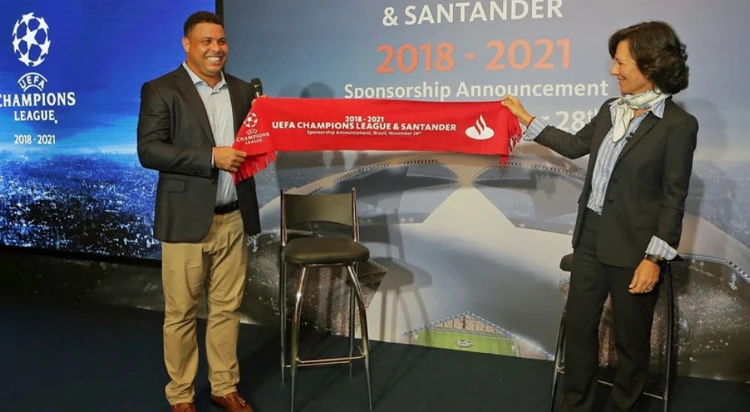 Ana Botín, Styrelseordförande, Banco Santander håller upp röd flagga med texten: UEFA Champions League & Santander 2018–2021