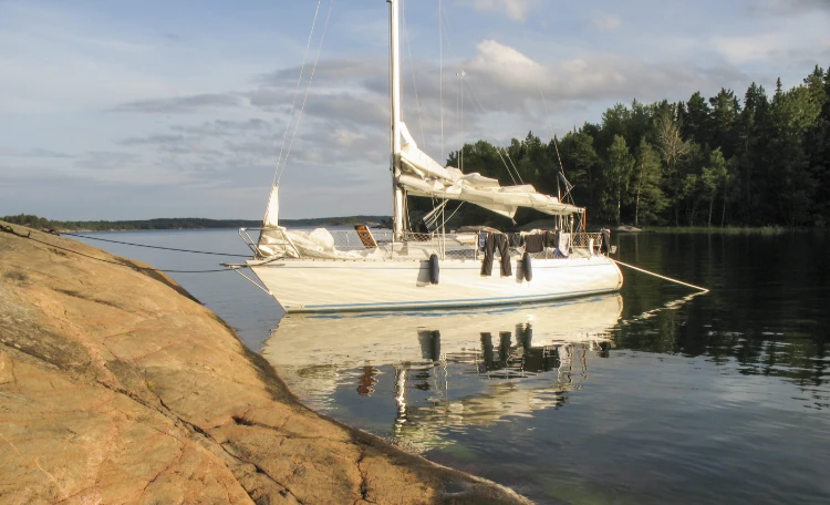 Segelbåt ligger förtöjd vid klippa